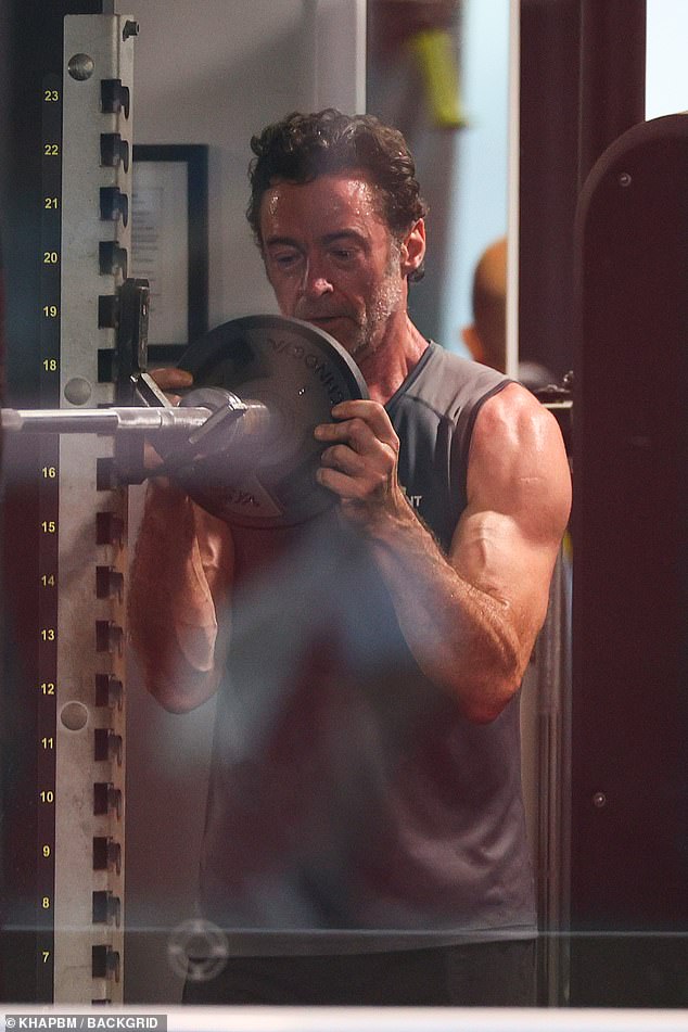 The Australian actor, 56, showed off his bulging biceps in a T-shirt while performing a dumbbell shoulder press at a Bondi gym.