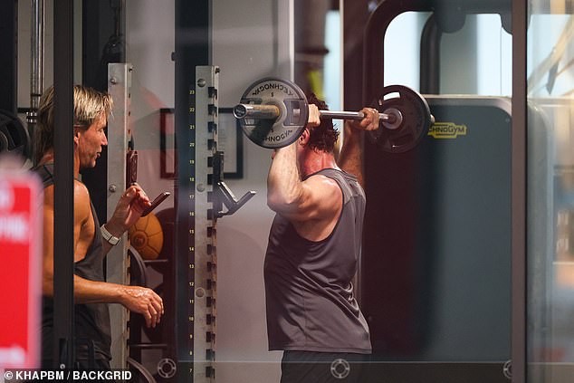 The Wolverine star completed his look with black shorts as he lifted heavy weights under the guidance of celebrity trainer and close friend Michael Ryan.