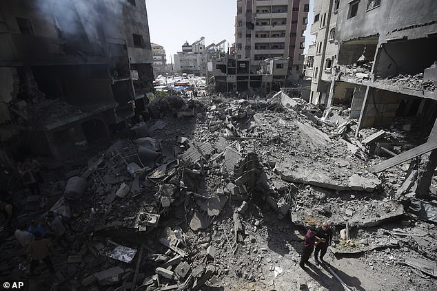 Palestinians watch the aftermath of an Israeli bombardment in the Nuseirat refugee camp, Gaza Strip, June 8, 2024