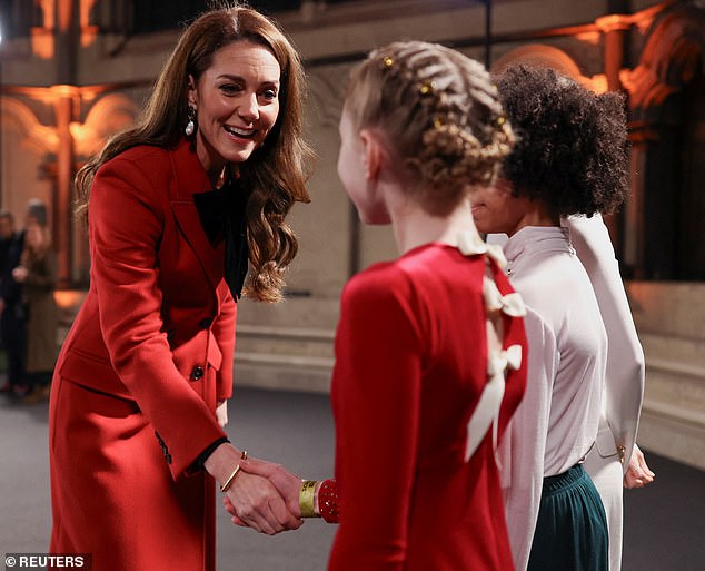 The royal mother of three greets the children who will perform at Westminster Abbey for her Christmas carol concert.