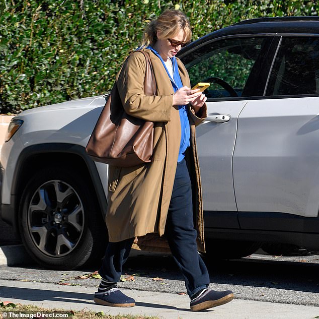 On Tuesday, the 34-year-old actress looked comfortable, wearing a tan trench coat with a blue zip-up jacket and sweatpants.