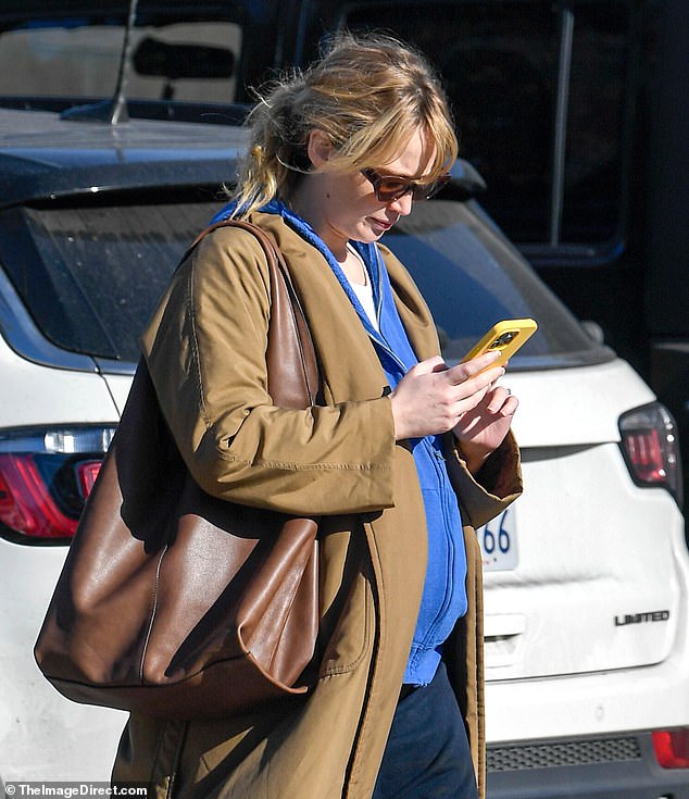 She accessorized with an oversized designer bag, sunglasses and navy slippers while wearing her highlighted locks in a messy ponytail.