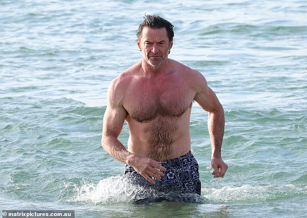 He put his muscular figure on display as he went shirtless in a pair of printed black shorts as he took a dip in the sea.