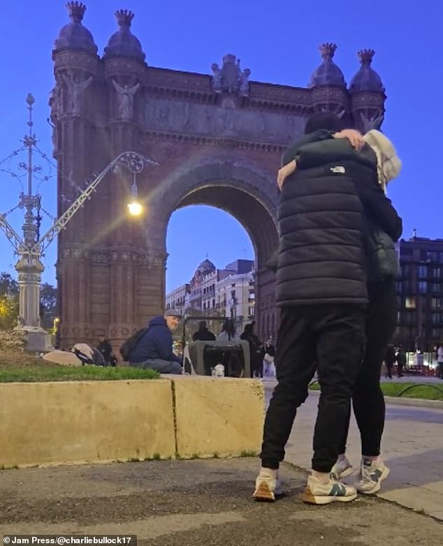 The two pause to hug each other, leaving the phone unattended, as the audience watches.