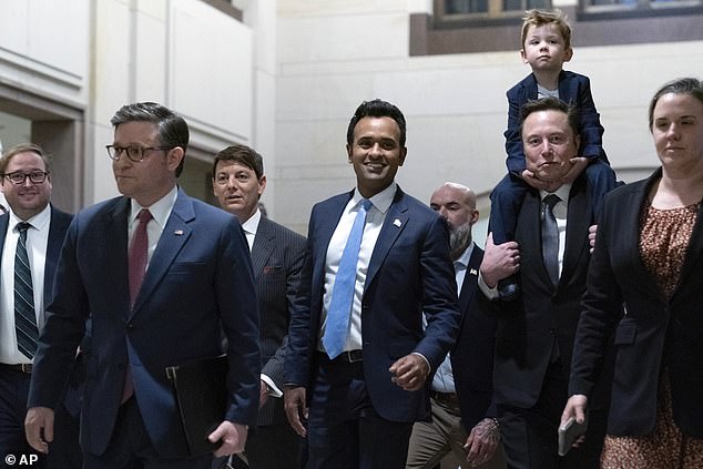 House Speaker Mike Johnson, R-La., from left, walks with Vivek Ramaswamy and Elon Musk, carrying his son to discuss President Donald Trump. ), on Capitol Hill in Washington, Thursday, December 5, 2024