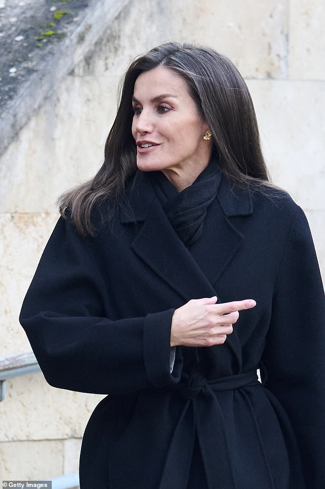 To combat the cold, the royal mother of two donned a knee-length black coat that was cinched at the waist with a matching belt.