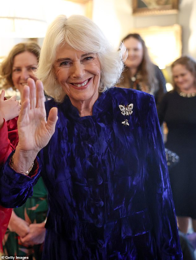 Queen Camilla greets and talks to a little girl as she welcomes children and families to Clarence House on December 12.