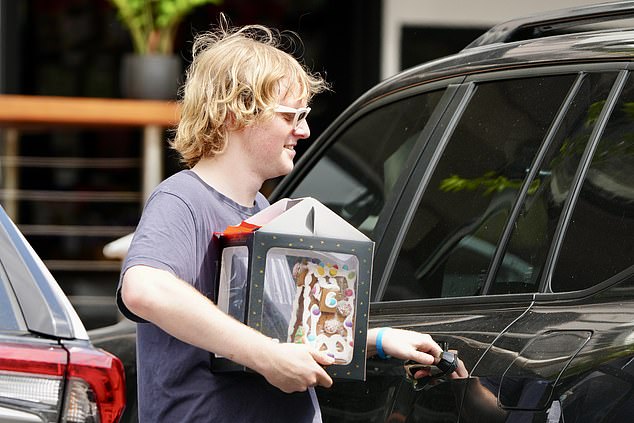 Karl's eldest son Jackson also joined the group and was seen carrying a gingerbread house from the car as he got into the holiday spirit.