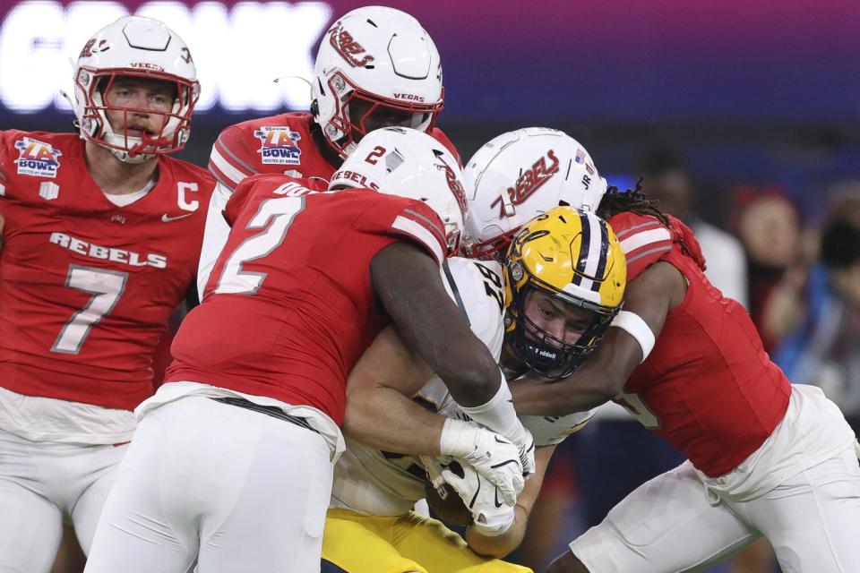 California tight end Jack Endries is tackled by UNLV's Antonio Doyle Jr. and Johnathan Baldwin during the LA Bowl