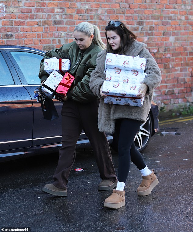 The influencer, accompanied by her friend Erin, took the gifts from the trunk of her Mercedes G Wagon dressed in brown sweatpants and a bomber jacket.