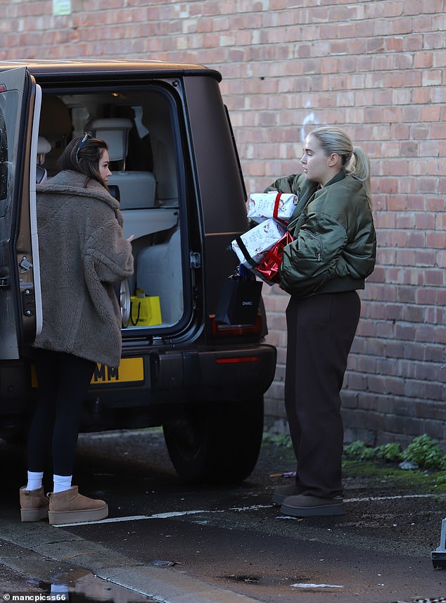 The reality star, 25, looked casual as she precariously balanced piles of Christmas presents to give to staff in her offices.