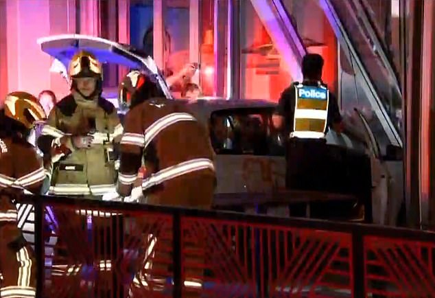 Emergency services officers appear on the scene at a Nando's on Barkly Street in Footscray, inner-city Melbourne, where a car was rammed into the front of the restaurant at 2.15am on Friday.