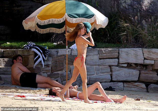 Max, 31 (left), was pictured alongside his ex Dina, 46, at Kutti Beach in Sydney on Tuesday. The famous 'naked artist' even sunbathed topless