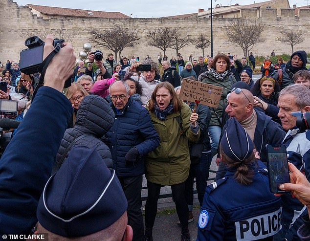 One of the rapists who served time in preventive detention is challenged by the crowd outside the court