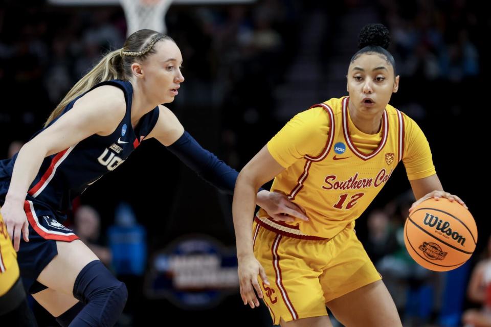 USC's JuJu Watkins, right, controls the ball in front of Connecticut's Paige Bueckers.