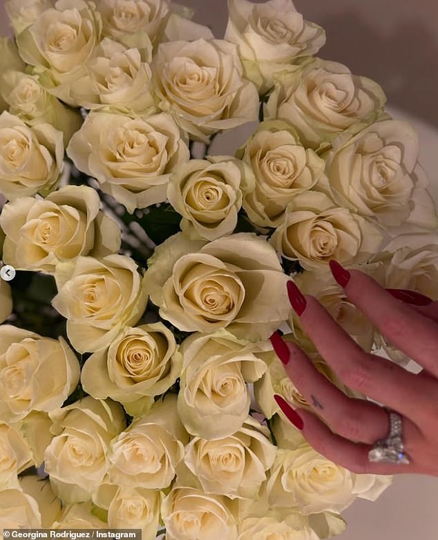 The star also shared a glimpse of a huge sparkling diamond ring as she showed off her red manicure in a snap of a bouquet of white roses.