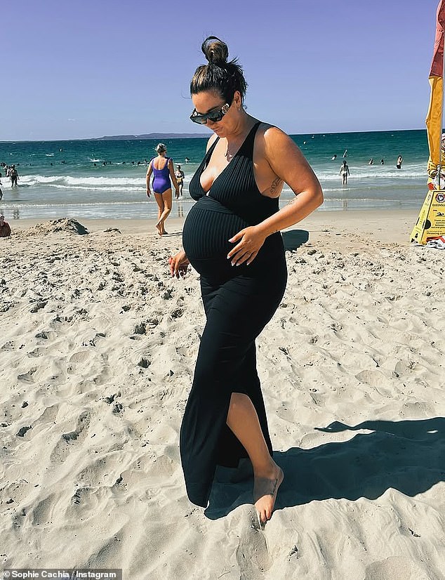 She shared a series of snaps of herself cradling her burgeoning baby bump while smiling on the beach in Noosa and left some name suggestions in a caption.