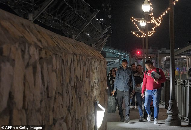 Venezuelan Jorluis Ocando (left) walks with other migrants after attending their CBP One appointment and crosses into El Paso, Texas on October 22