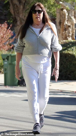 She additionally wore a white shirt that was layered with a light gray sweater that was partially zipped in the front