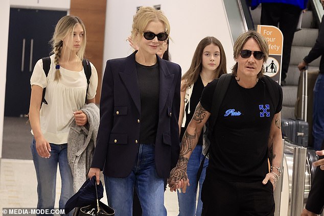 She put on a very affectionate display with musician Keith, 57, as the pair sweetly walked hand in hand through arrivals after disembarking from their Qantas flight.