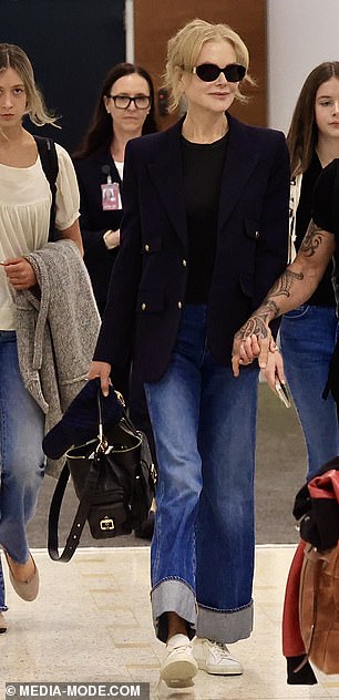 She styled her ensemble with a sleek navy blazer and white sneakers.