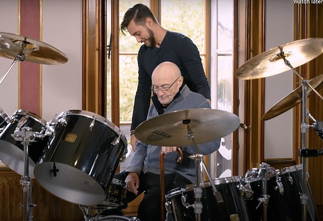 In a moving scene, the frail-looking musician makes an emotional return to his personal drum kit, sitting in front of the instrument and holding a pair of drumsticks (pictured with his son Nic).