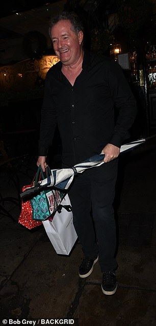 Piers looked dapper in a black shirt and jeans as he left the event with three gift bags and an umbrella.