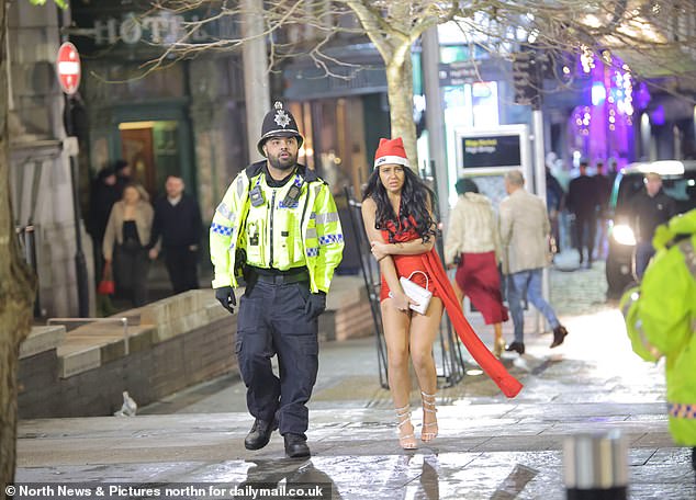 NEWCASTLE: Woman in Santa hat clutches her purse as she walks down the street with a police officer