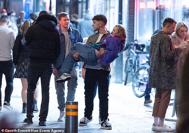 CARDIFF: A woman carries a woman through the center of a busy street