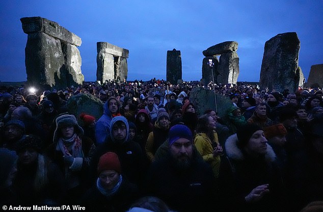 People take part in winter solstice celebrations during sunrise at the prehistoric monument Stonehenge on Salisbury Plain in Wiltshire.