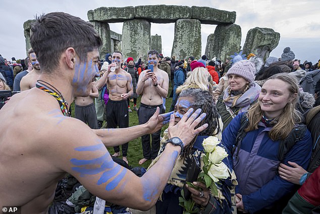 A person's face is painted with blue paint as they take part in winter solstice celebrations at Stonehenge, England, on Saturday.