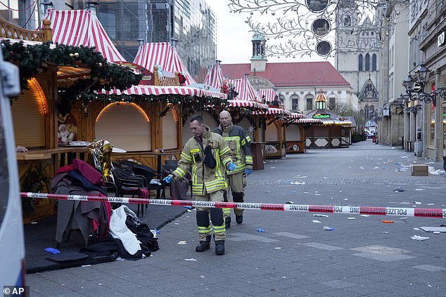 Firefighters work at a cordoned-off Christmas market where a car plowed into a crowd on Friday night in Magdeburg.