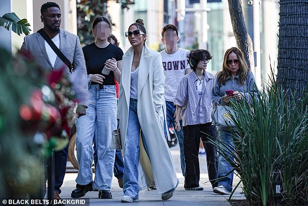 Flanked by her beaming team, including her daughter Emme, JLo glided through the luxurious shopping district, clearly in high spirits as they shared smiles and laughs.