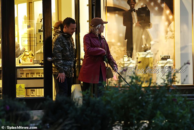 She added a pair of black high-heeled boots and a beige bag, while hiding her famous face under a brown baseball cap.