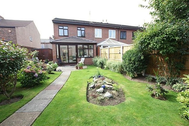 The backyard house with stone path and manicured lawn.