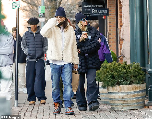 The guitarist added a pair of sturdy snow boots to his outfit and was later seen wearing a black beanie.