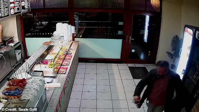 The 50-year-old doctor is photographed casually strolling into the Saale Grill and grabbing a beer from the fridge on Thursday, near his home in the city of Bernburg.