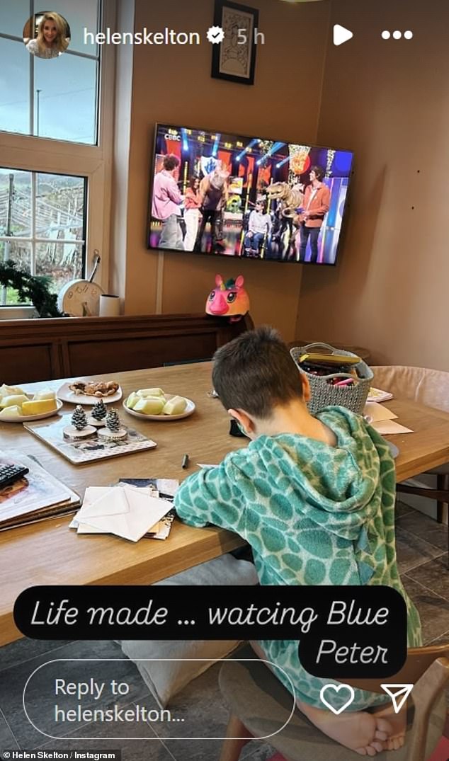 In a touching snap shared to the star's Instagram Story on Sunday, Helen showed her son coloring at a large table, dressed in a dinosaur onesie with an episode of the hit show playing in the background.