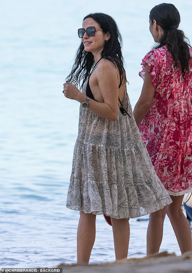 Andrea was seen throwing a ruffled white chiffon beach cover-up over her bikini.