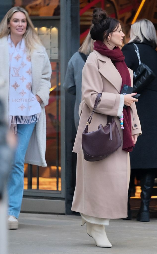 She accessorized the look with a pair of heeled boots and a sleek leather bag and pulled her brunette hair into a top bun.