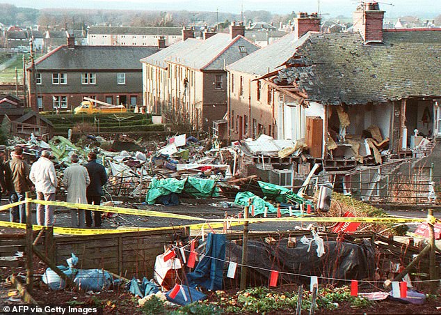 Residents watch the scene of devastation in Lockerbie on December 21, 1988.