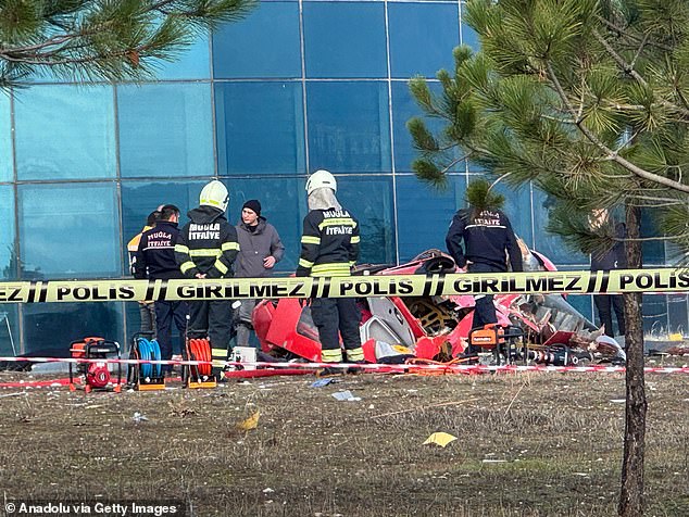 Forensic experts are seen examining the wreckage of the air ambulance helicopter after the crash.