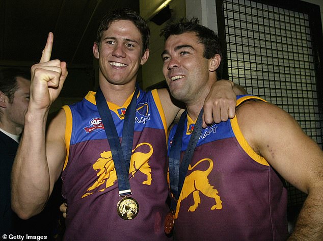 Shattock (left) is pictured with former teammate turned Geelong AFL coach Chris Scott after starring in the Lions' 2002 grand final.