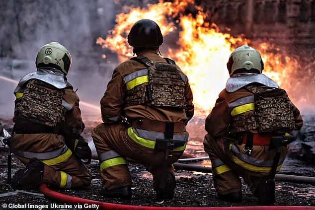 Rescue workers respond at the site where fragments of a Russian ballistic missile fell in the city's Holosiivskyi district on December 20, 2024 in kyiv.