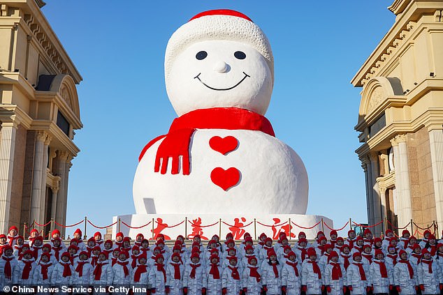 A performance is performed during the launching ceremony of the giant snowman with a red scarf at Harbin Music Park on December 17, 2024 in Harbin, China's Heilongjiang province.