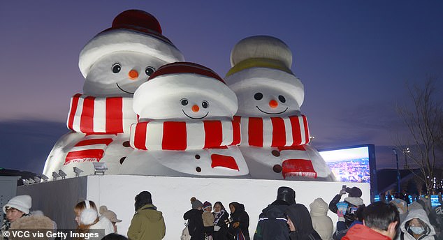 Three snowmen in red hats and scarves welcome tourists at the entrance to the 26th Harbin Ice and Snow World Cup