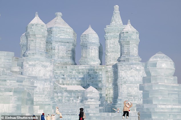 Tourists pose for selfies on the stairs of one of the ice palaces.