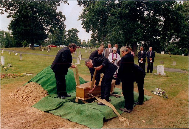 The body is lowered into its grave at Haywards Heath, Sussex