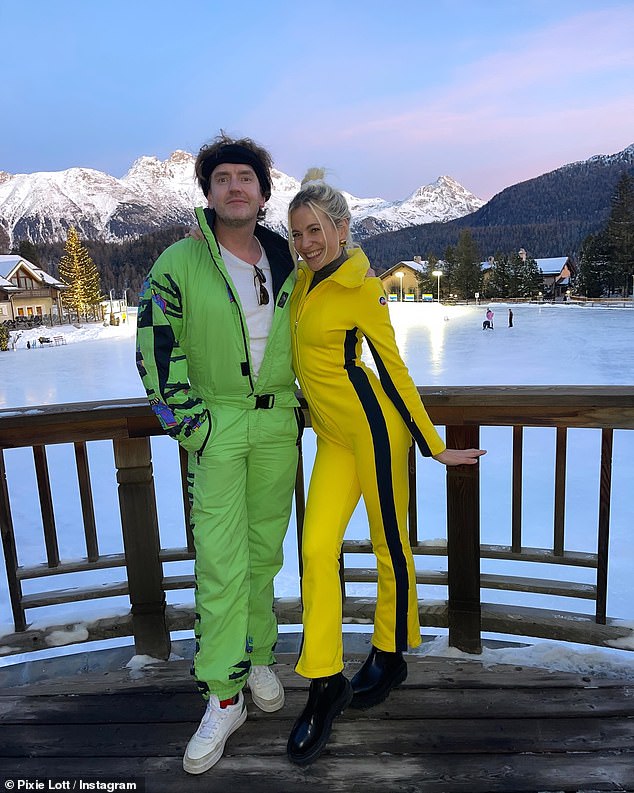 Pixie wrapped herself in a black thermal one-piece underneath and stayed comfortable in a pair of chunky black boots as she posed with a friend who donned a green ski suit.