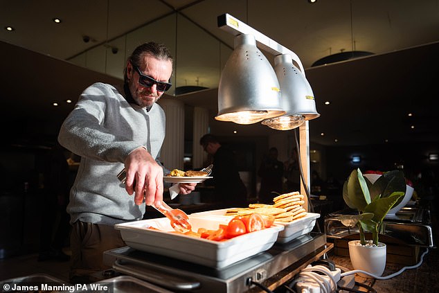 A man helps himself to a breakfast during the opening of Crisis's Christmas services in central London, as the charity sees unprecedented demand to help rough sleepers.